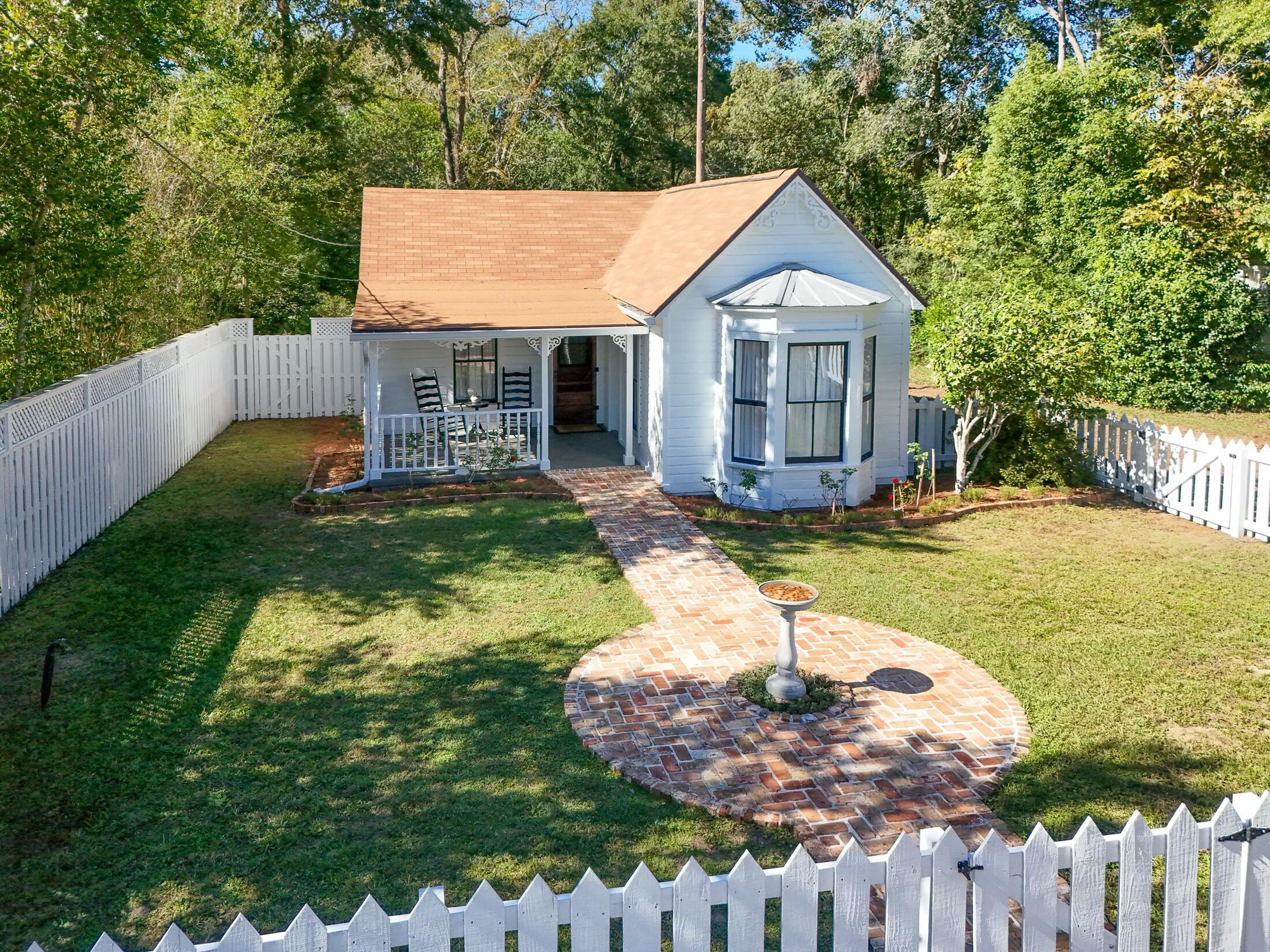 a front view of house with yard and trees in the background