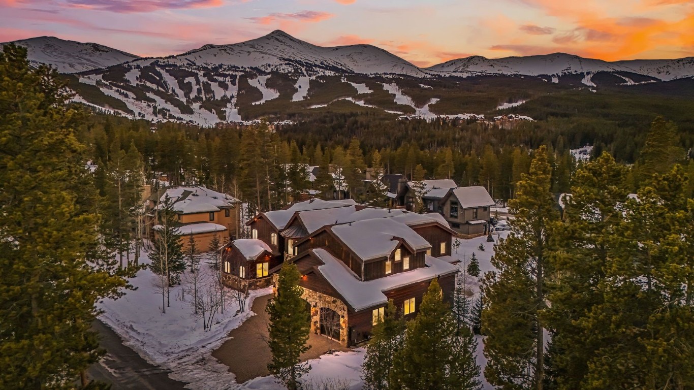 an aerial view of a house with a mountain