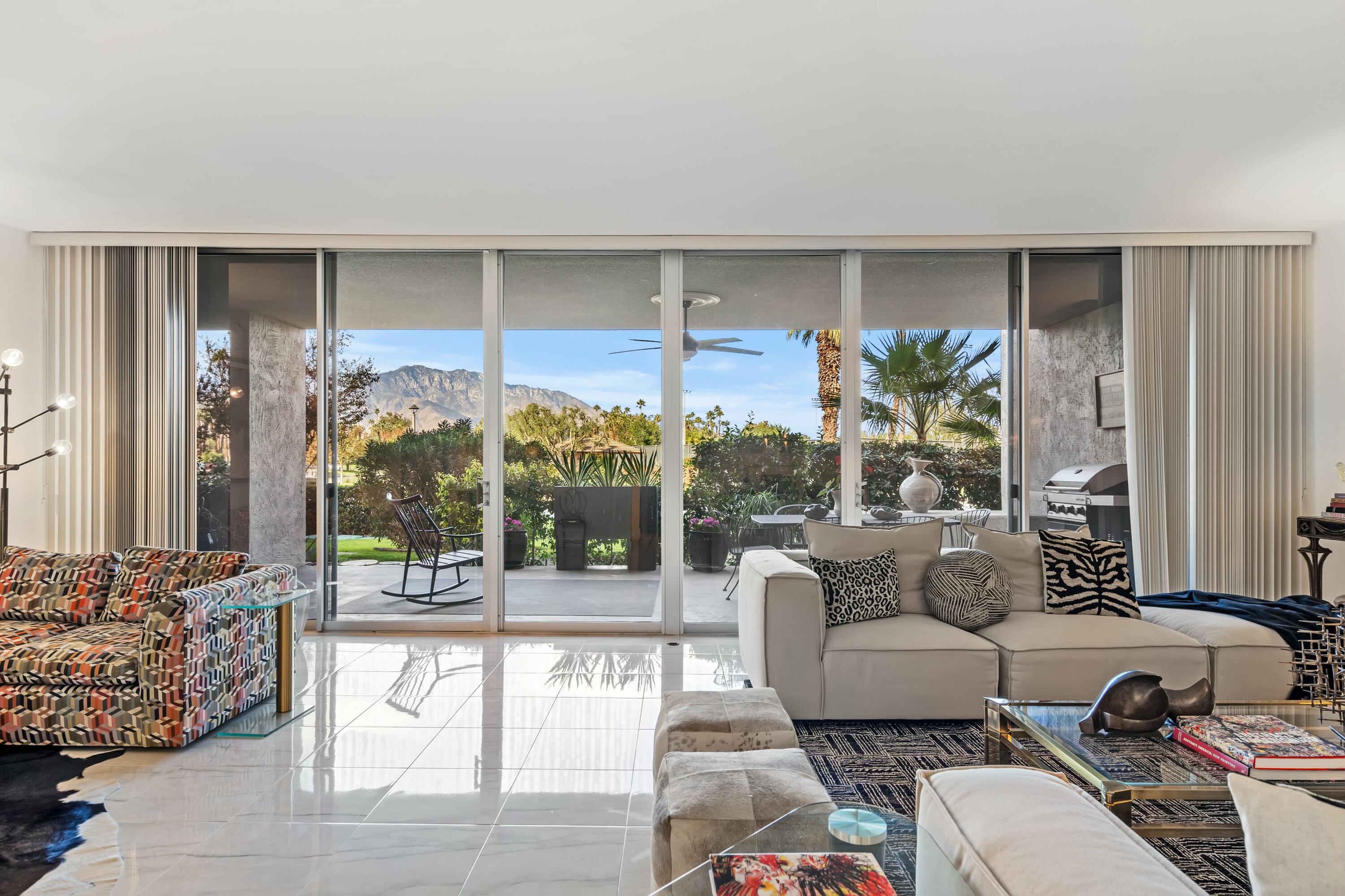 a living room with furniture and a floor to ceiling window