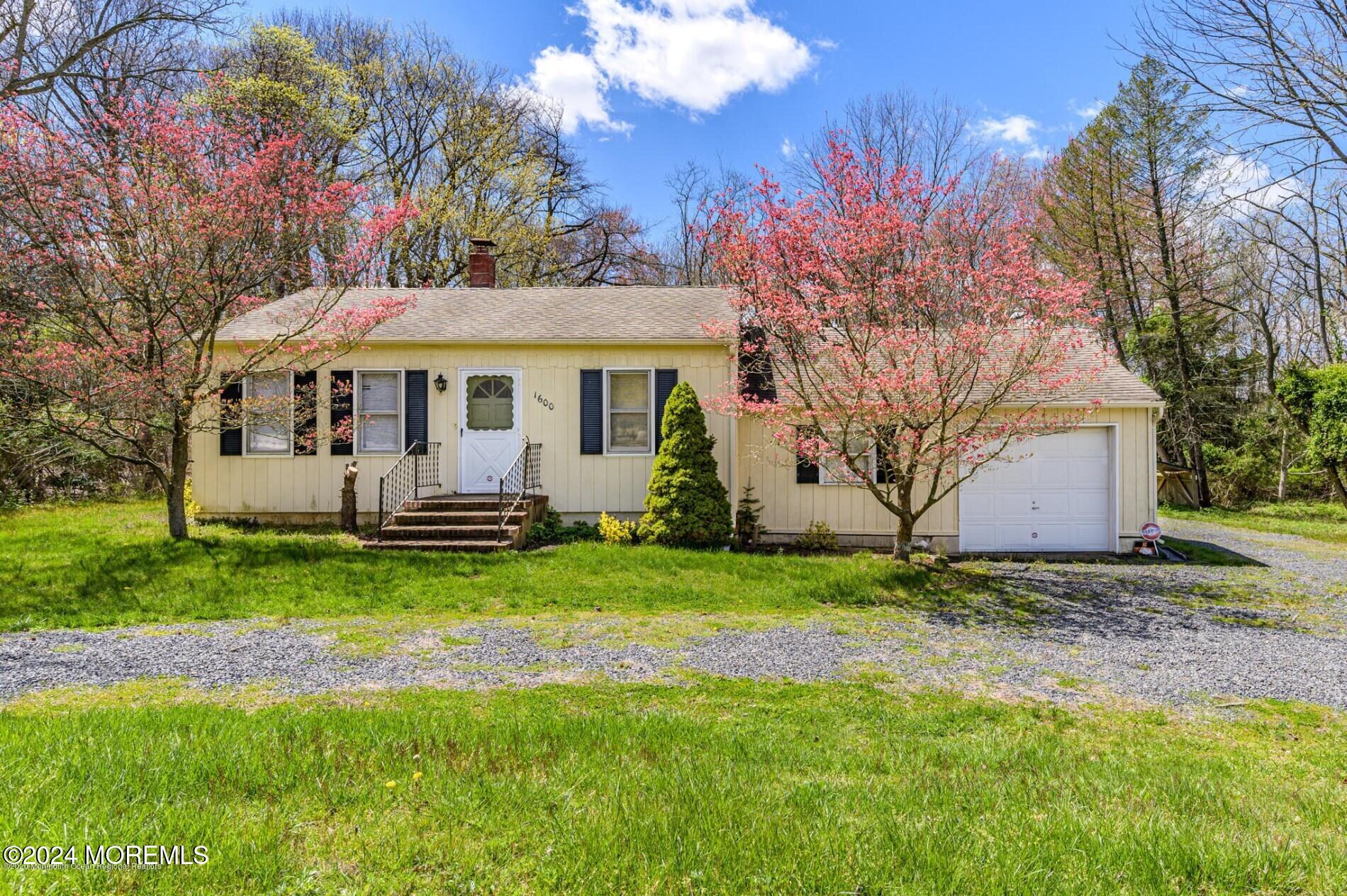 a view of a house with backyard and a tree