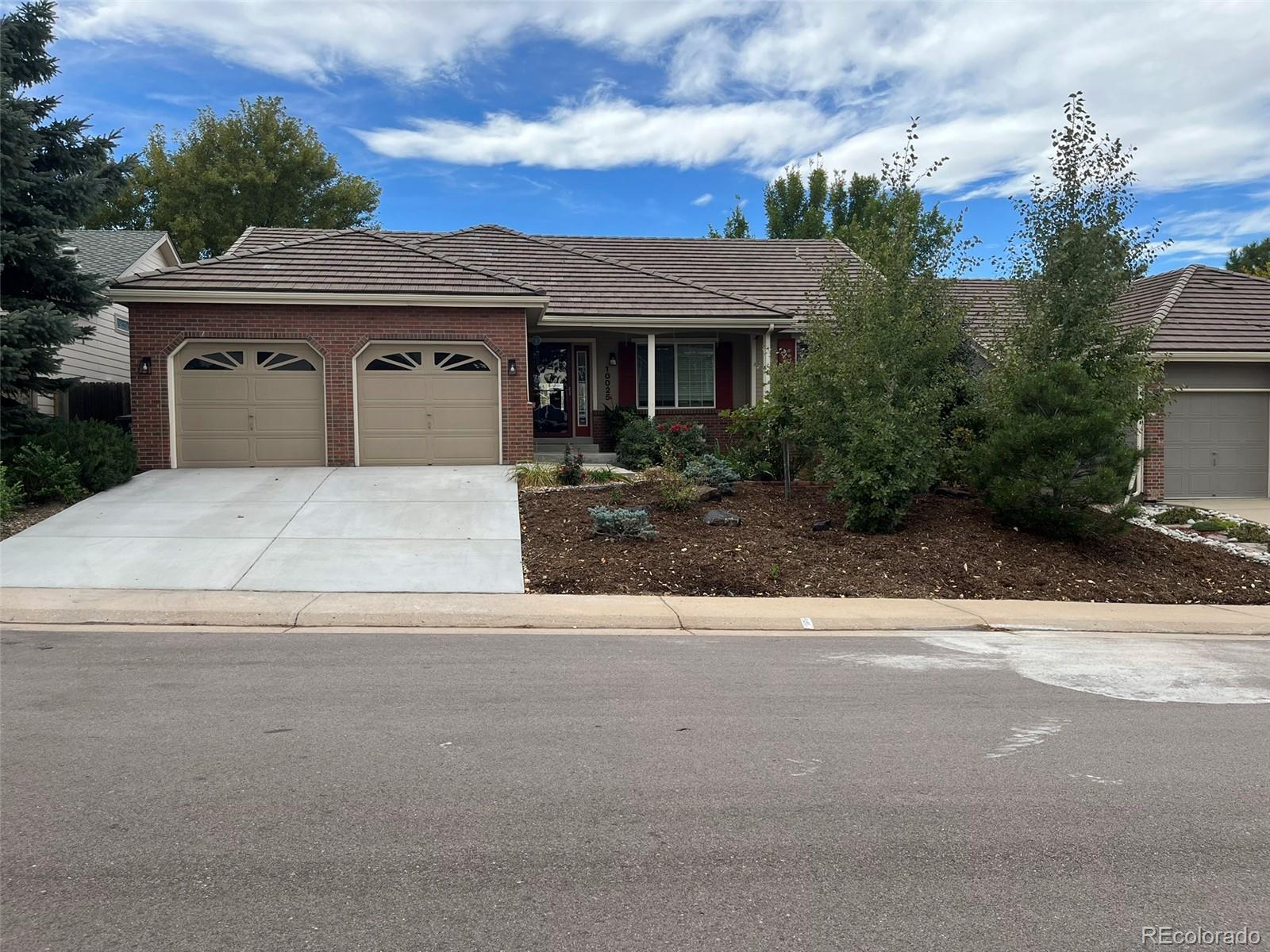 front view of a house with a yard and a garage