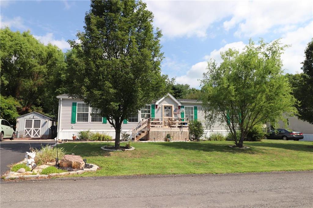 a front view of a house with a garden and trees