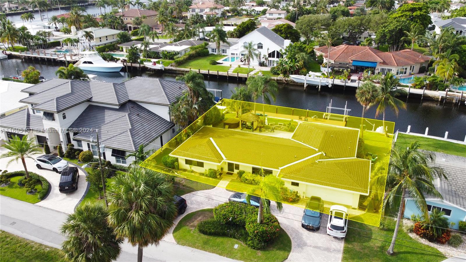 an aerial view of a house with swimming pool and outdoor seating