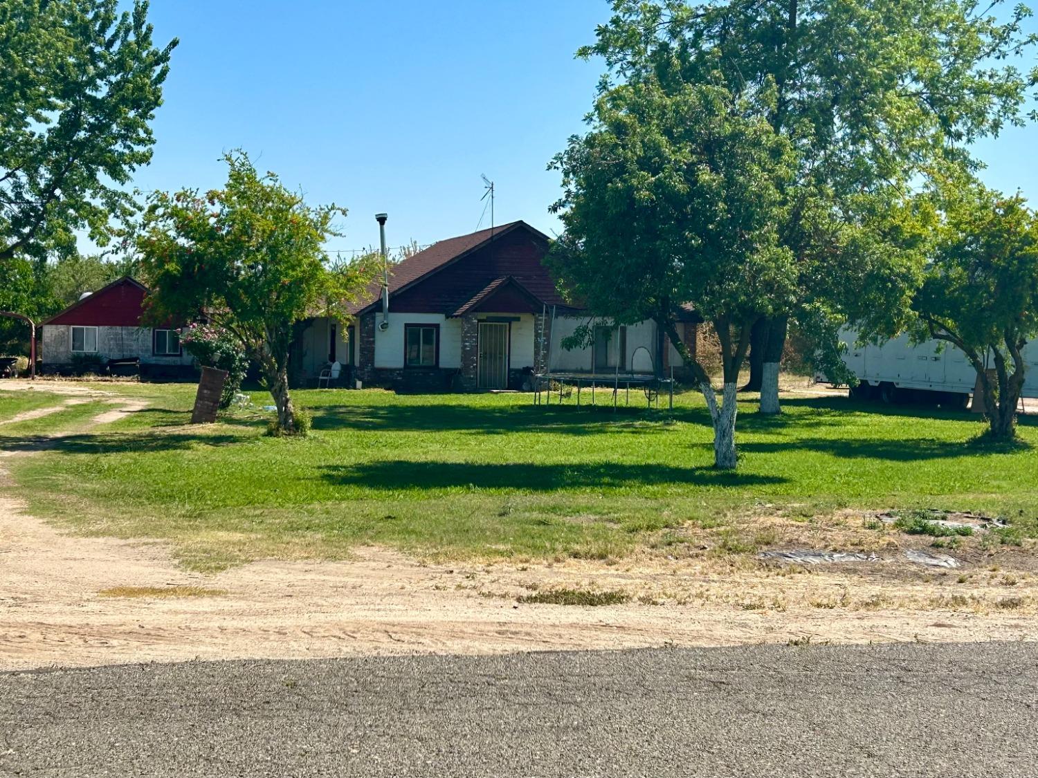 a front view of a house with a yard and trees