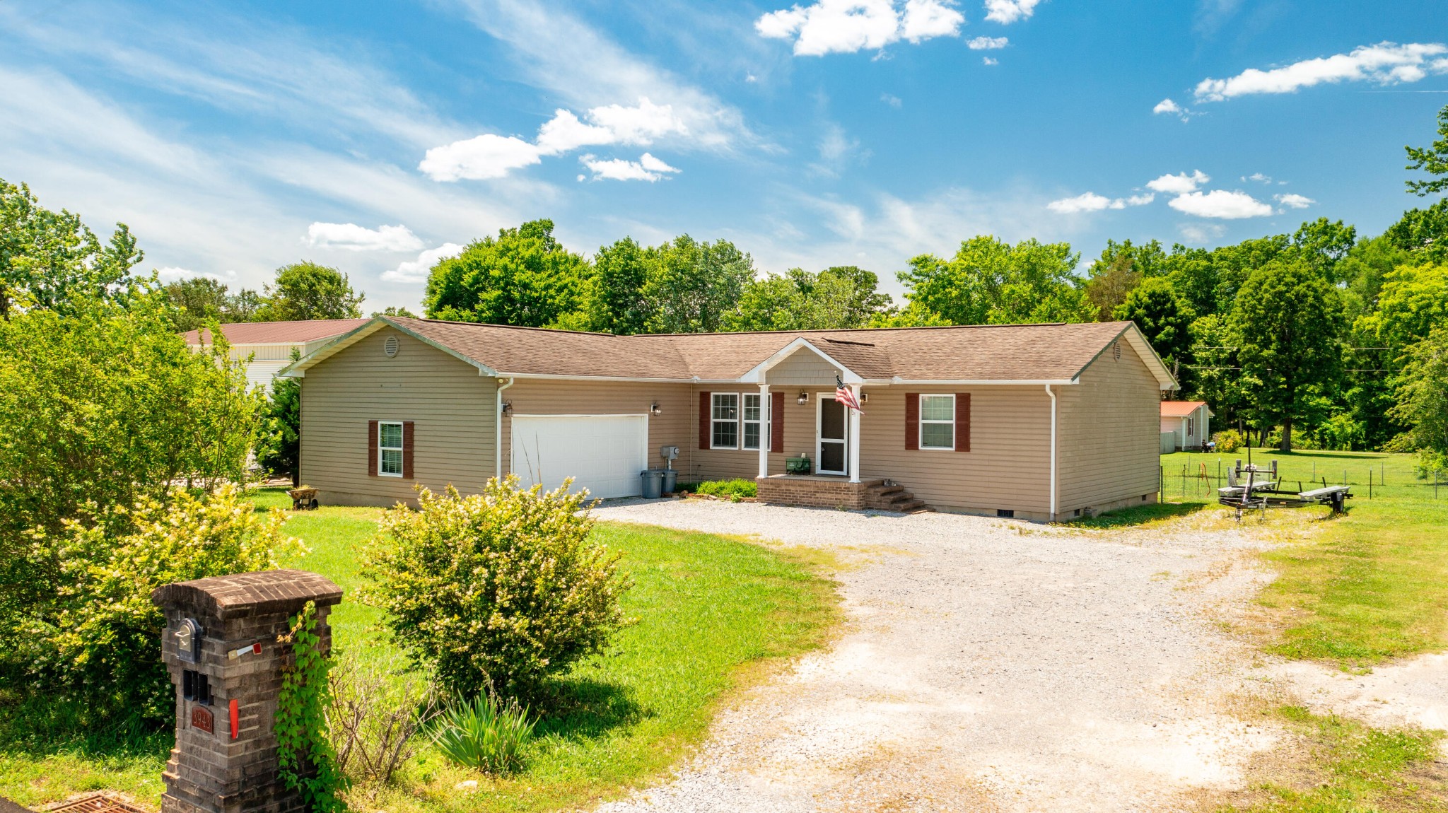 a front view of house with yard and trees around