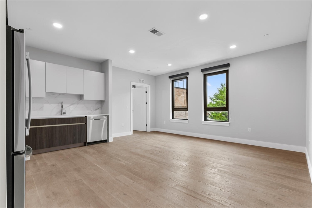 a view of kitchen with a sink and dishwasher a refrigerator with wooden floor