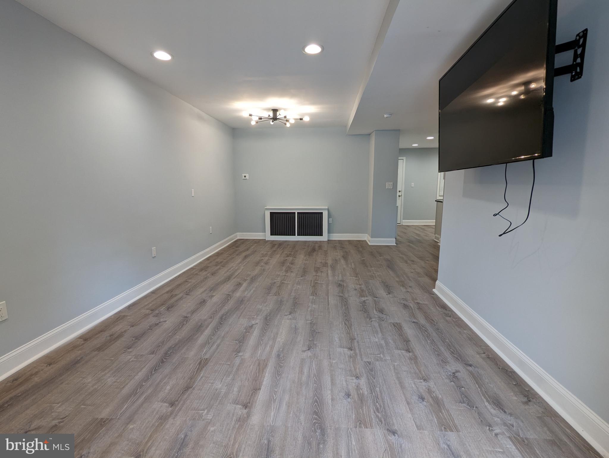 a view of a livingroom with a flat screen tv and wooden floor