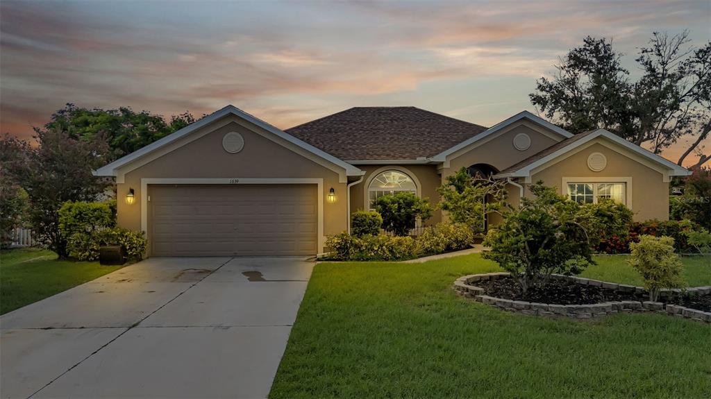 a front view of a house with a yard and garage