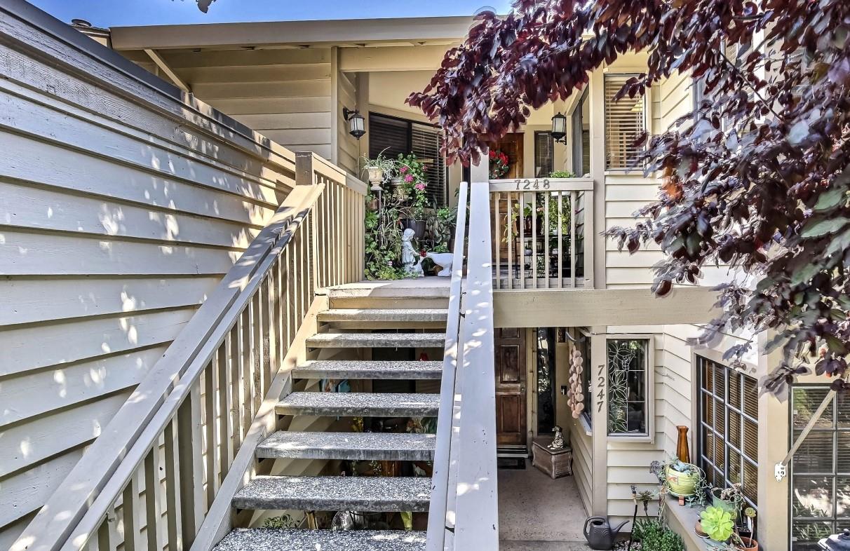 a view of a building with stairs and wooden fence