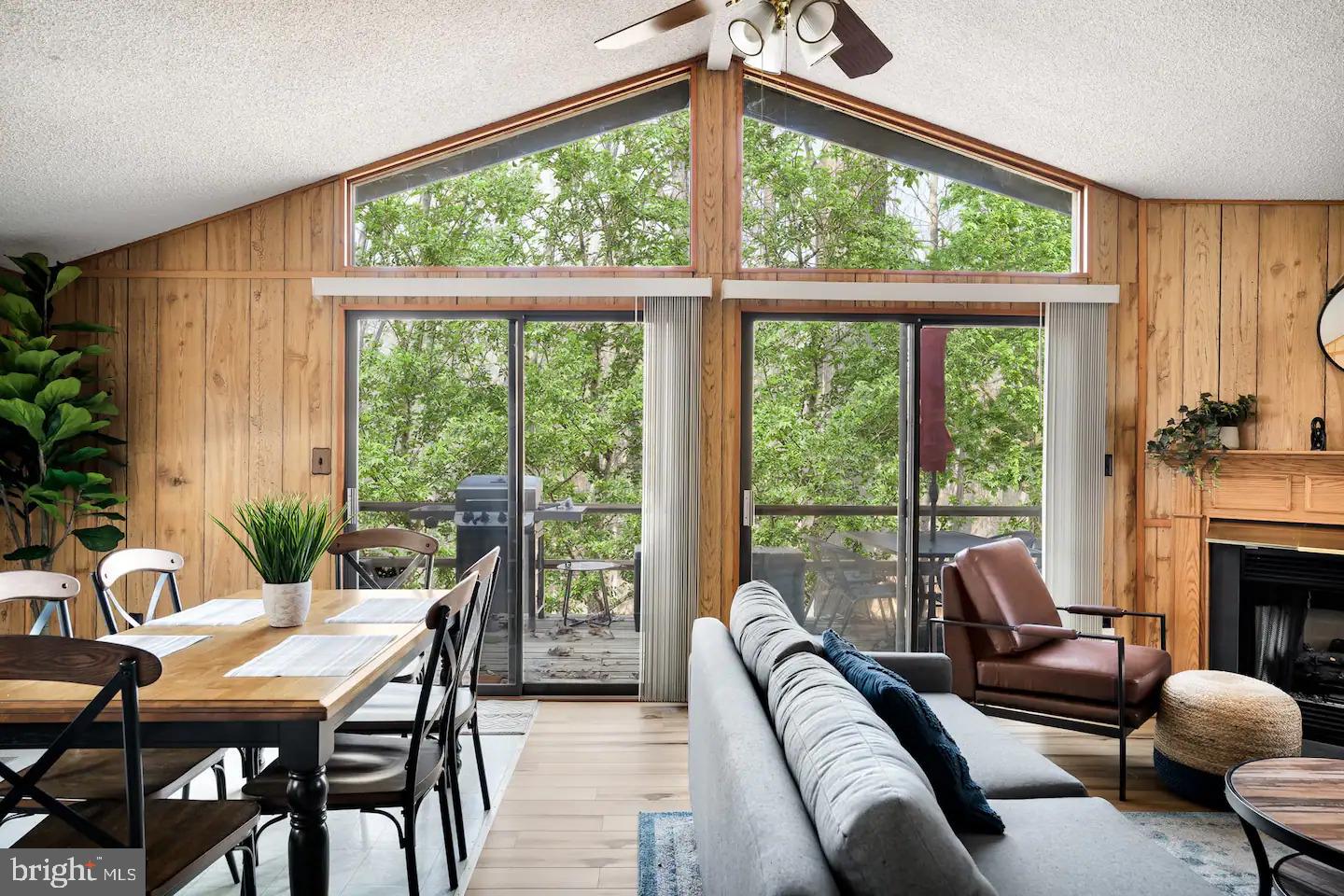 a living room with furniture a fireplace and a large window