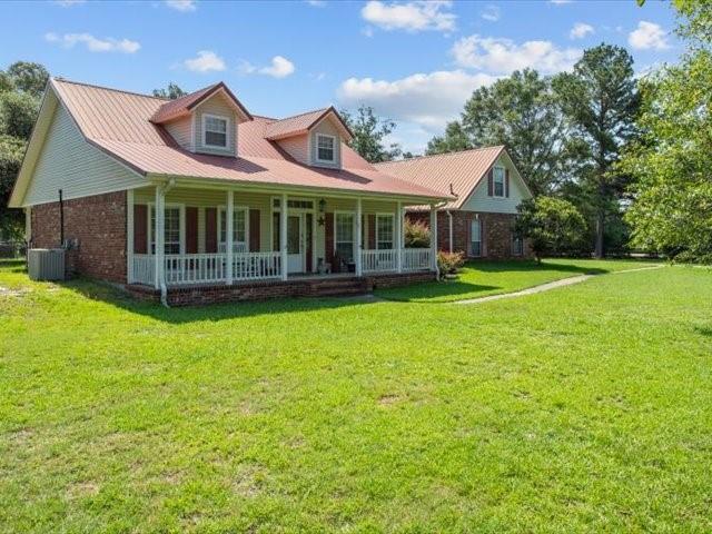 a view of a house with a big yard and large trees