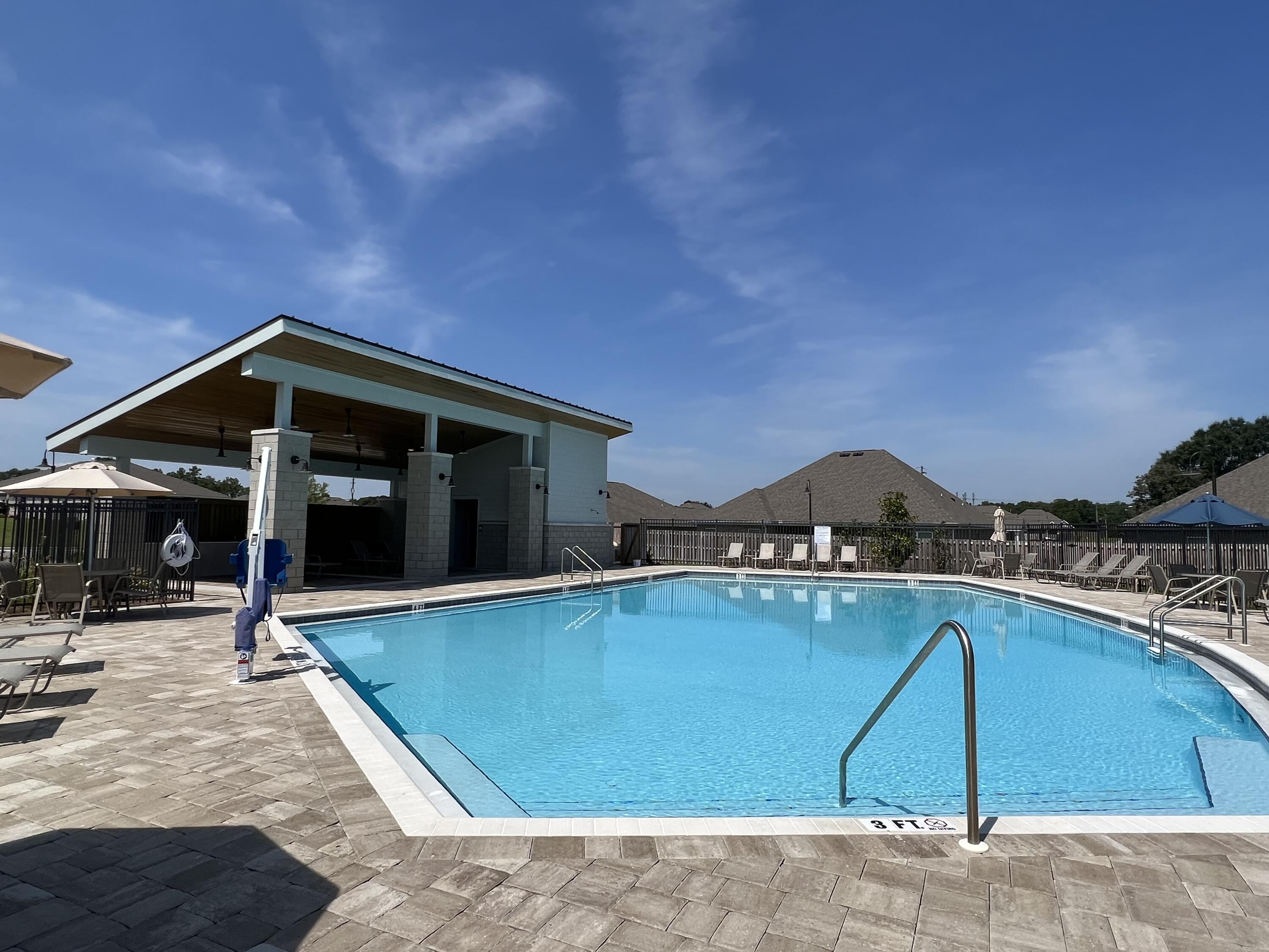 a view of swimming pool with lawn chairs