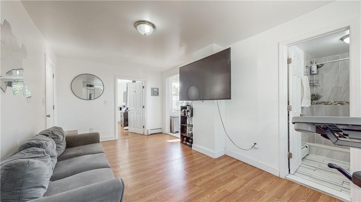 Living room with a baseboard radiator and light hardwood / wood-style flooring