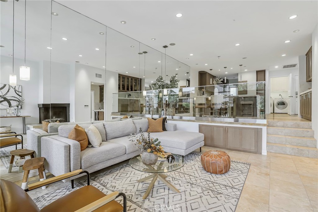 a living room with furniture and a view of kitchen