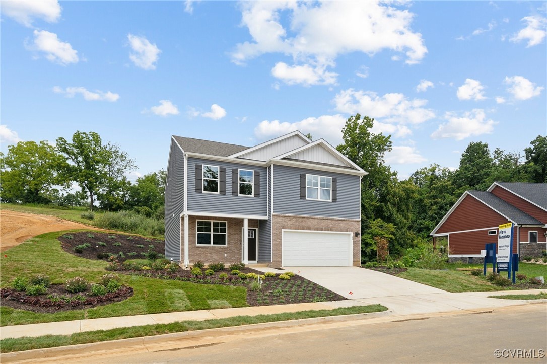 View of front of home with a garage and a front la