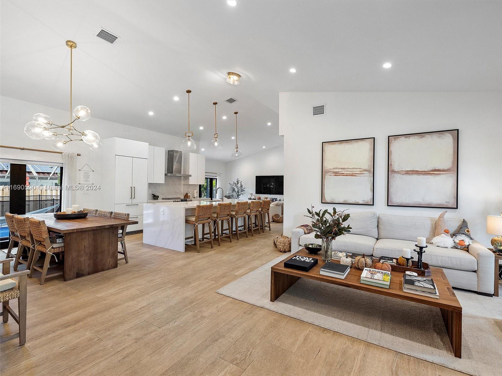 a living room with furniture kitchen view and a large window