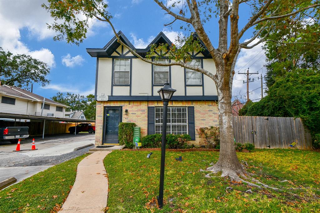 Charming standalone home with a welcoming front yard and mature trees, offering privacy and curb appeal.