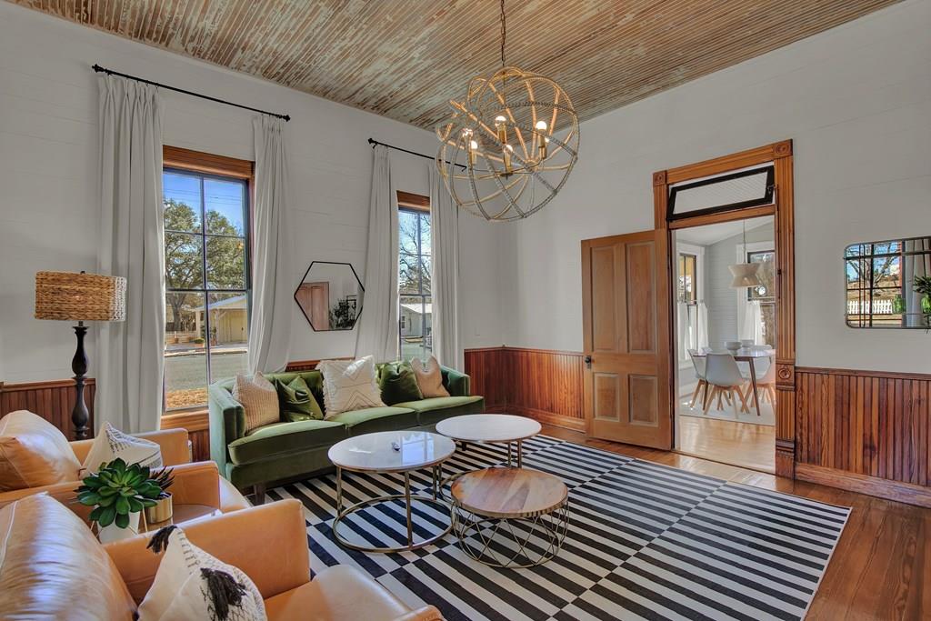 a living room with furniture a chandelier and a window