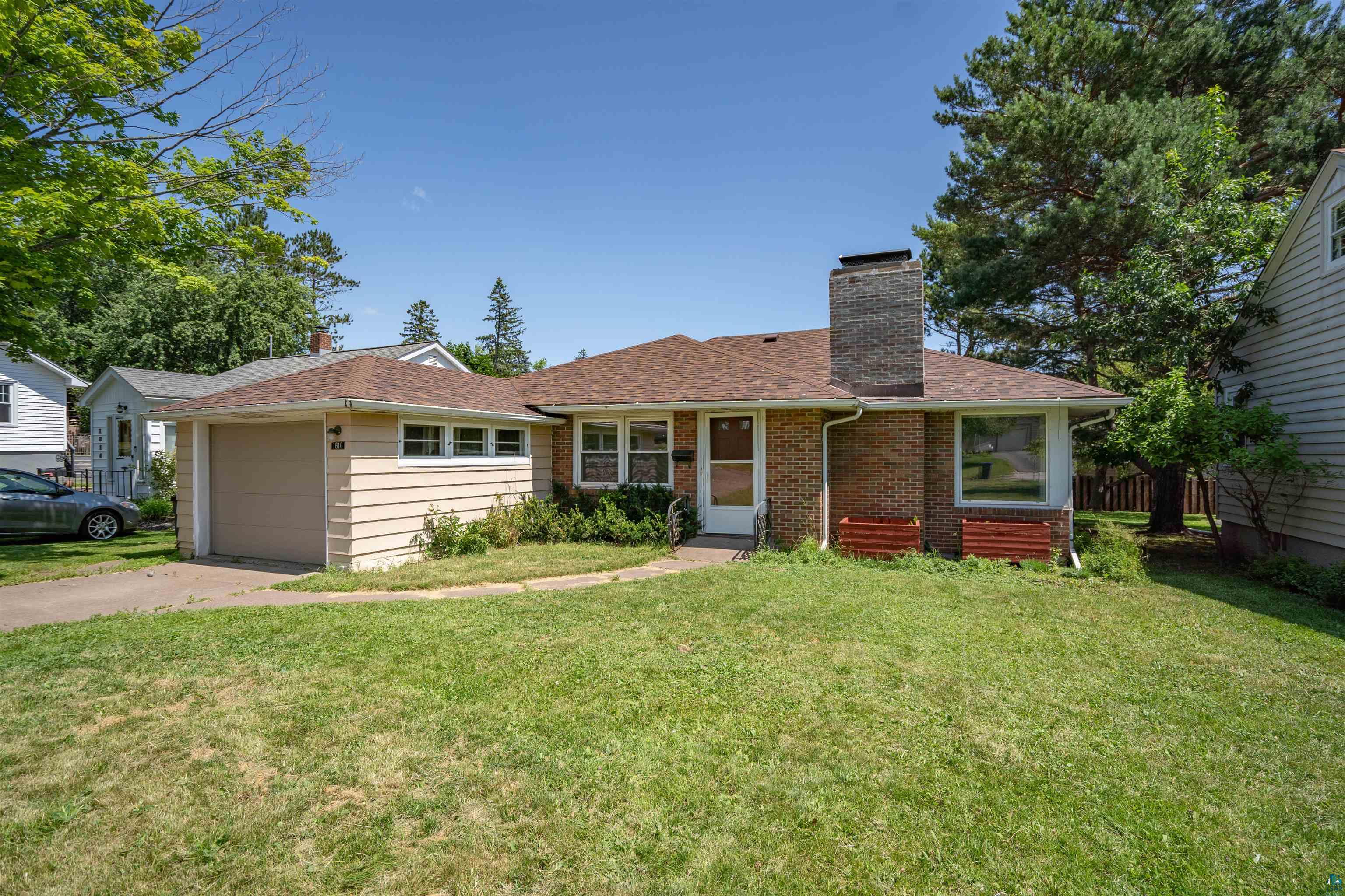 Ranch-style home with a garage and a front lawn