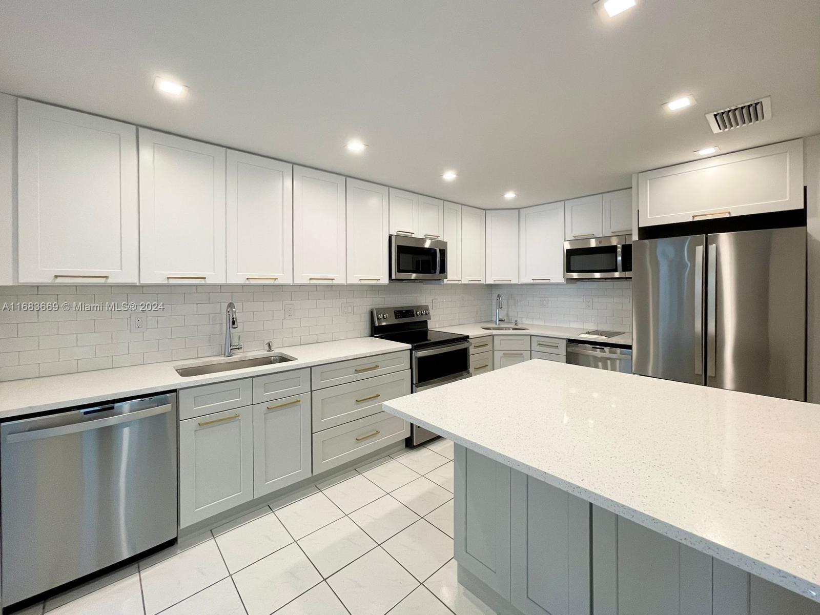 a kitchen with a sink a microwave and refrigerator