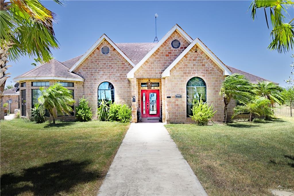 a view of a house with a yard and potted plants