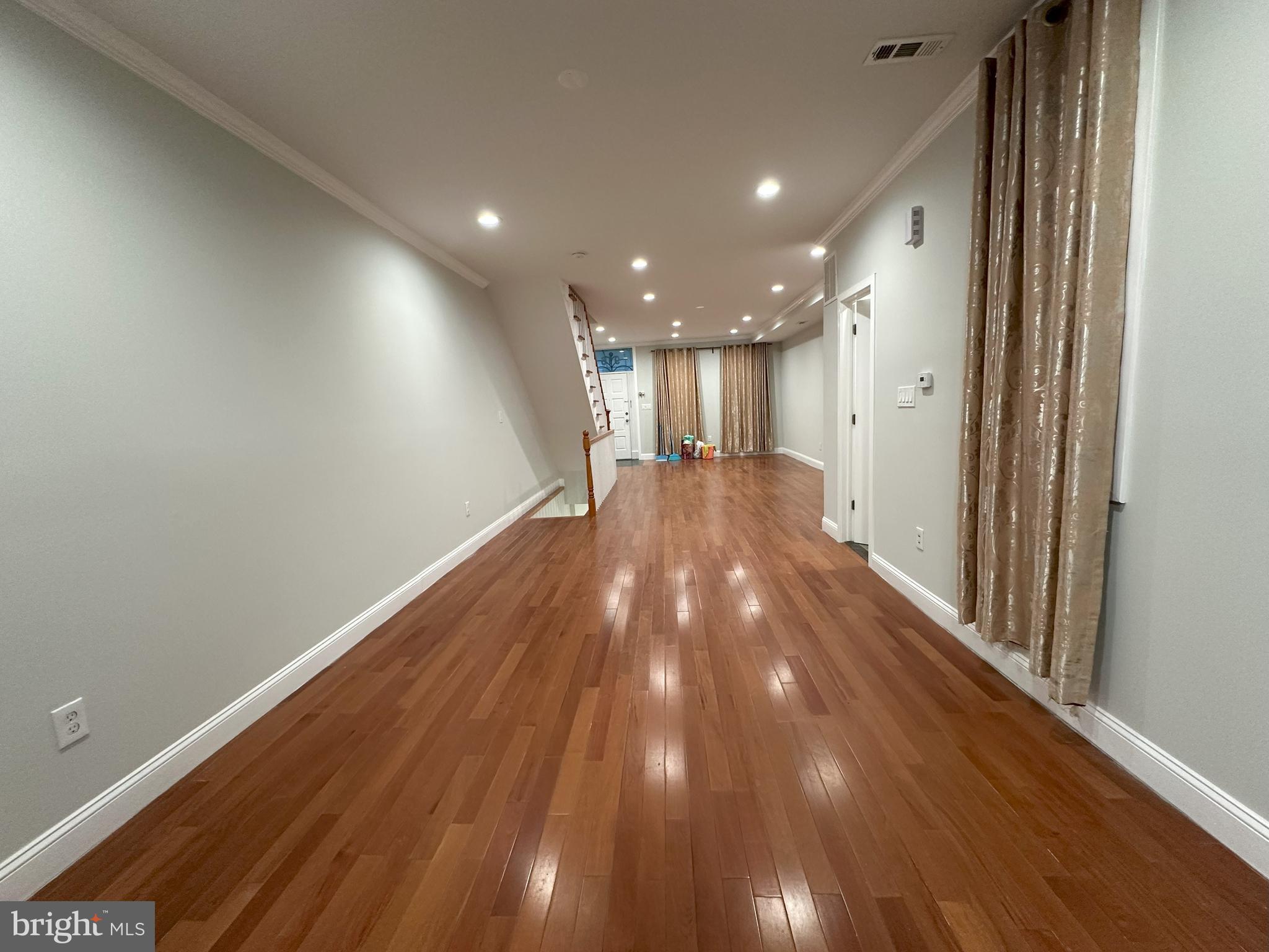 a view of empty room with wooden floor