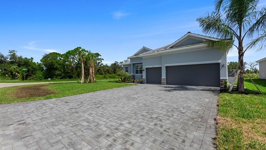 a view of a house with a yard and palm trees