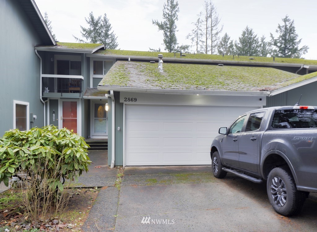 a front view of a house with a garden and parking space