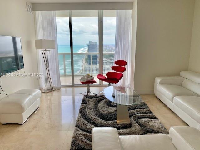 a living room with furniture and a floor to ceiling window