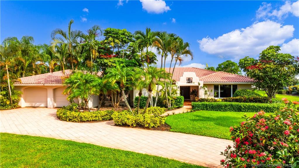 a front view of a house with a yard and potted plants