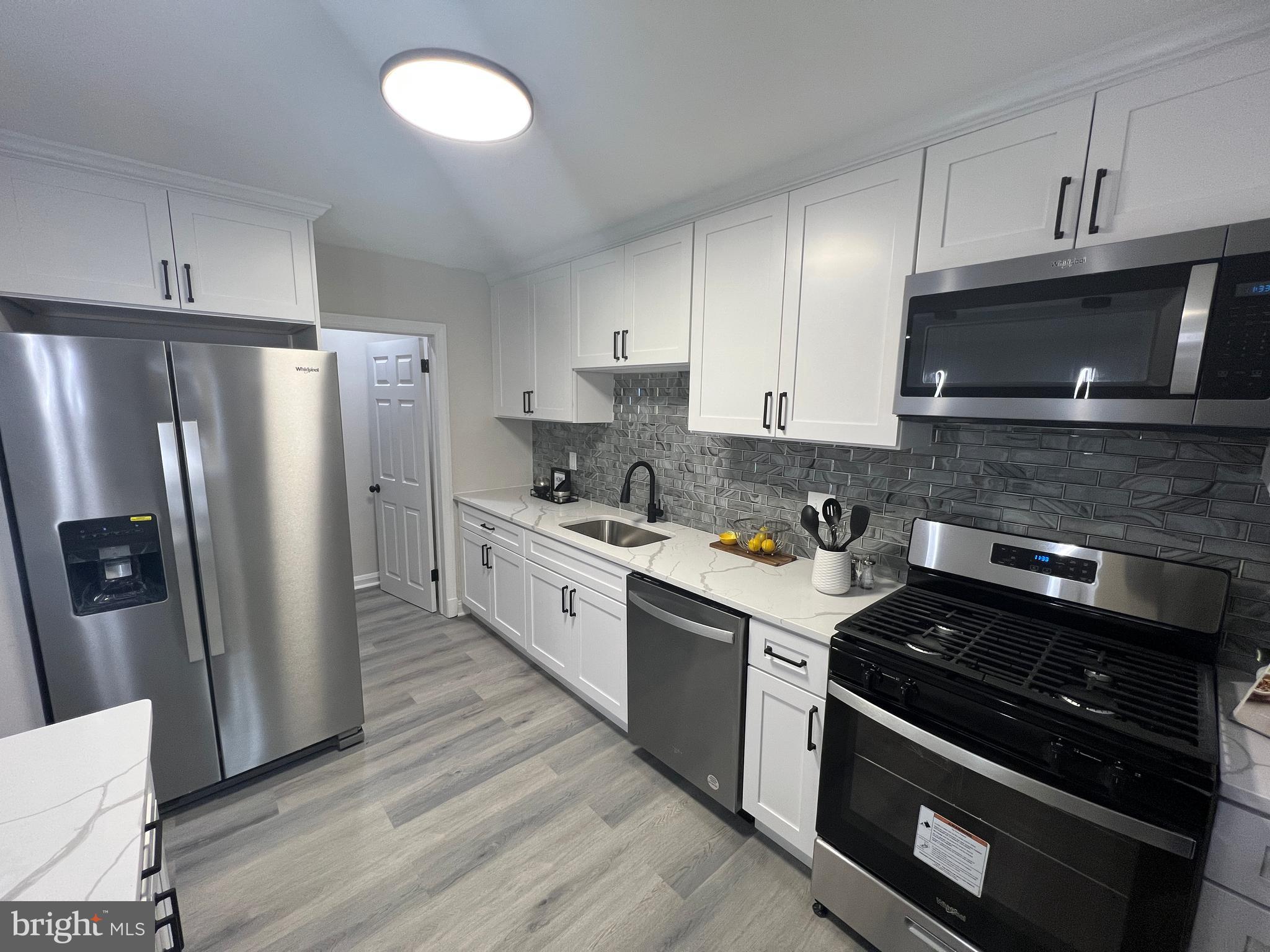 a kitchen with stainless steel appliances granite countertop a stove a refrigerator and a microwave