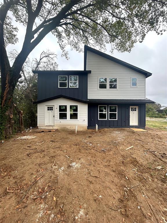 a front view of a house with a large tree