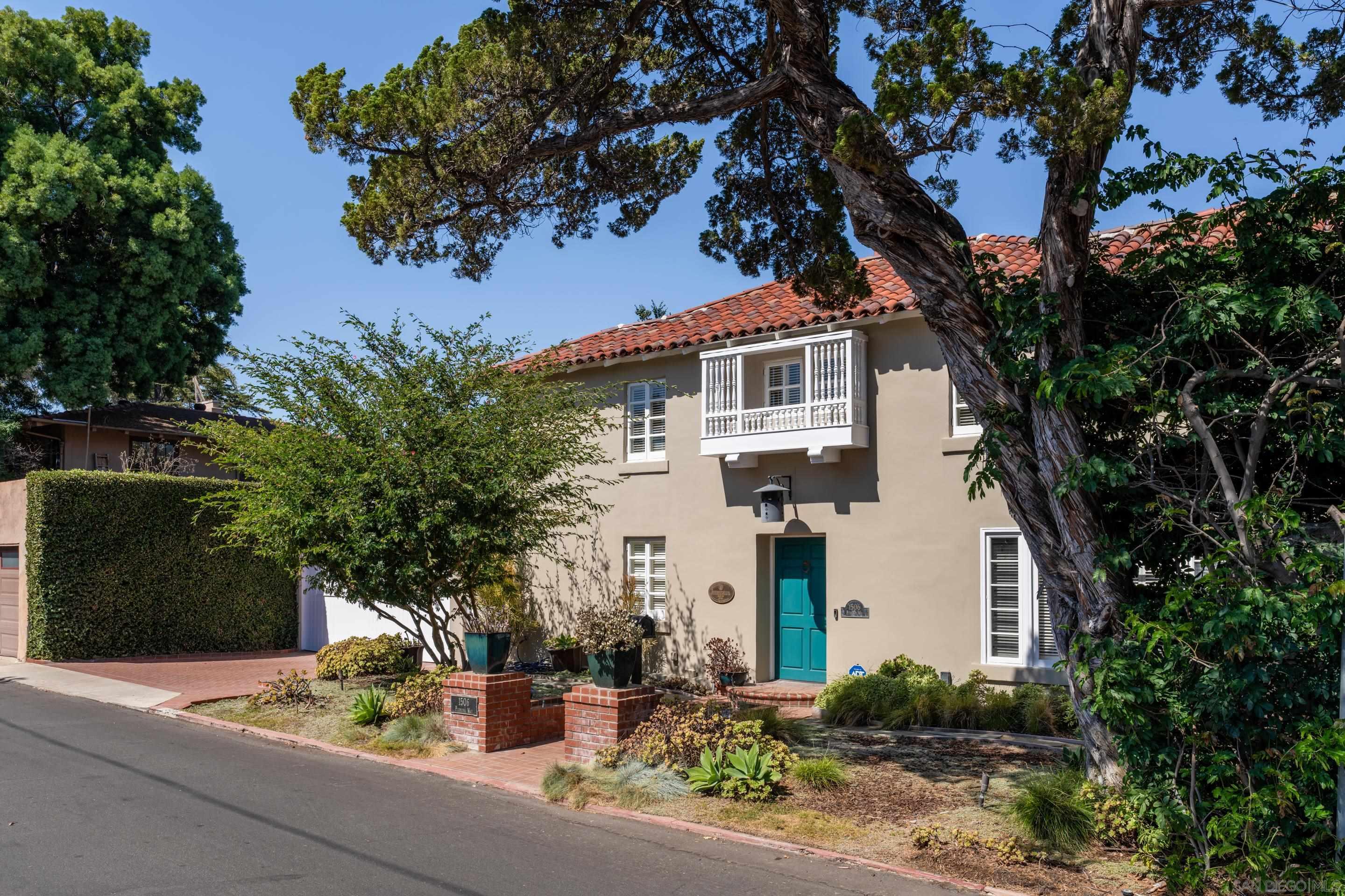 a front view of a house with plants and trees