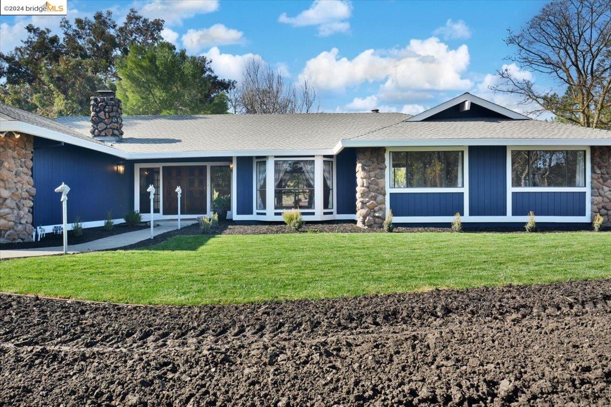 a front view of a house with a garden and yard