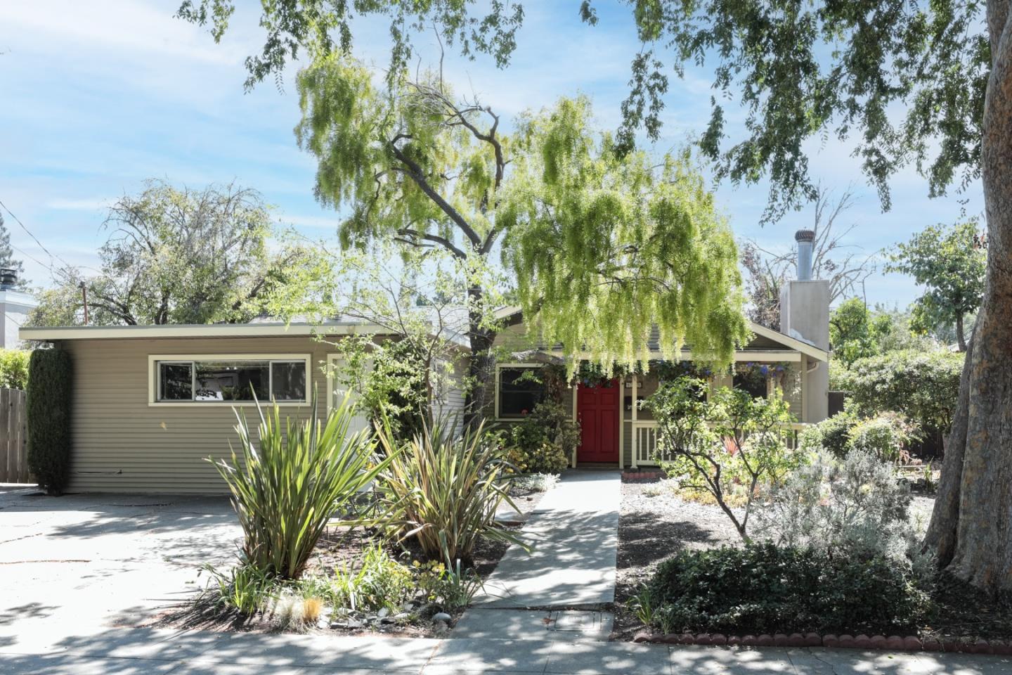 front view of house with potted plants and a yard