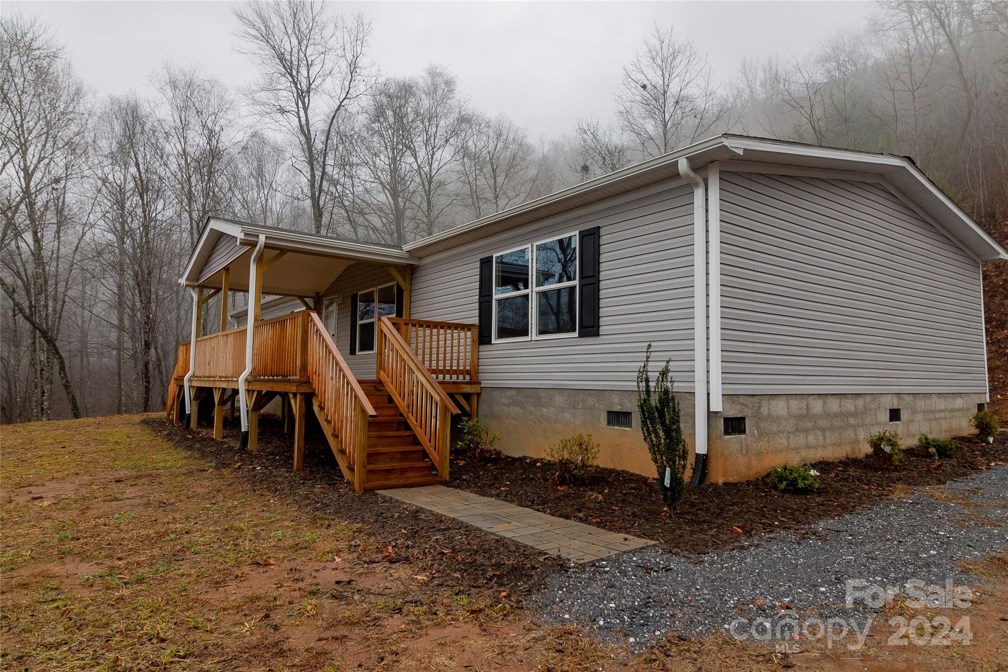 a view of a house with a yard and wooden fence