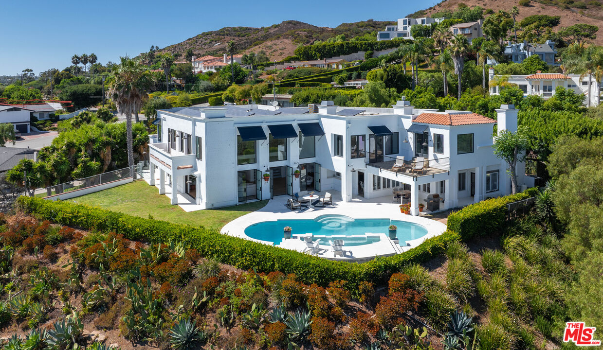 a view of a house with a garden and swimming pool