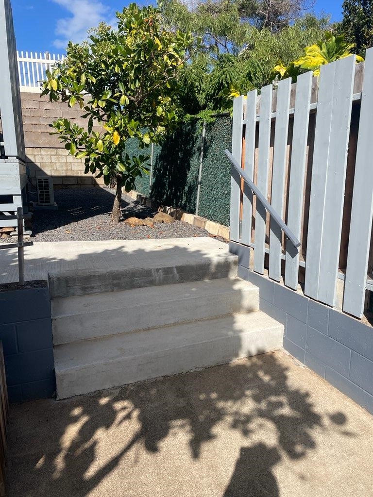 a view of a yard with wooden fence