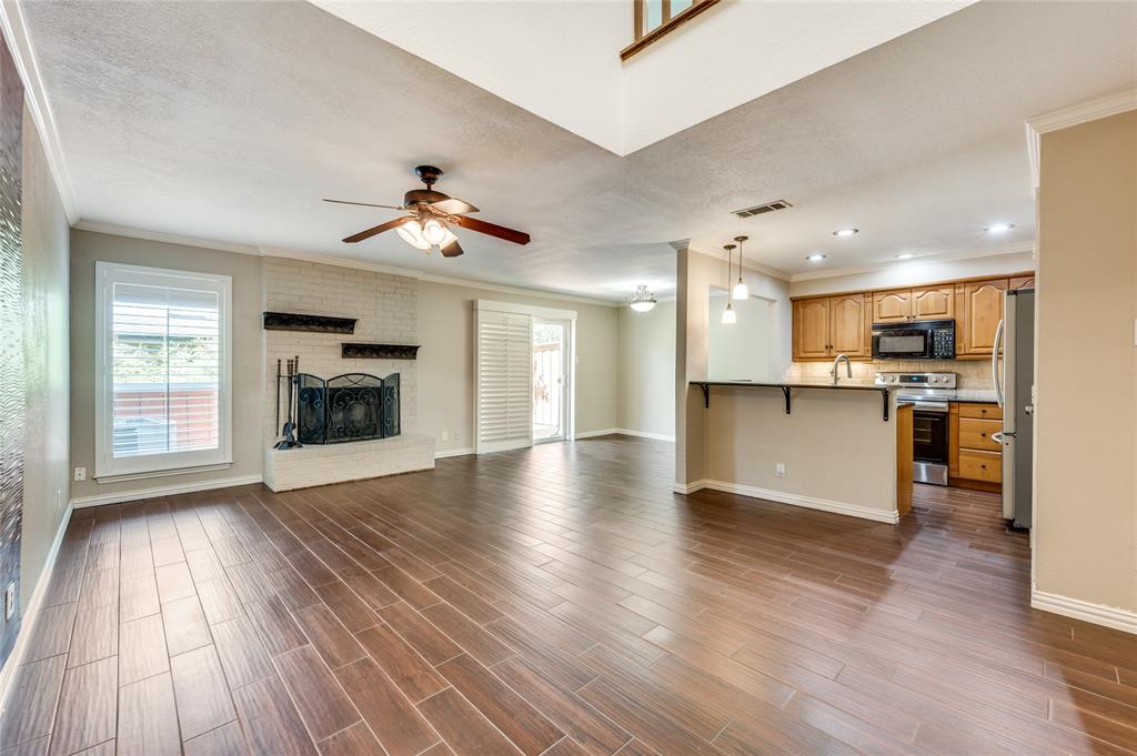 a view of kitchen with a sink a fireplace and a window