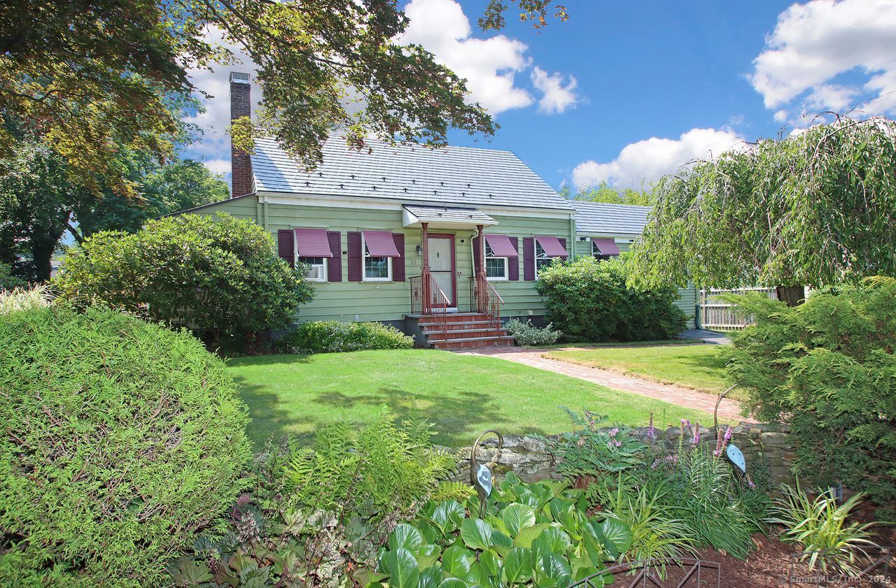 a front view of a house with a yard and trees