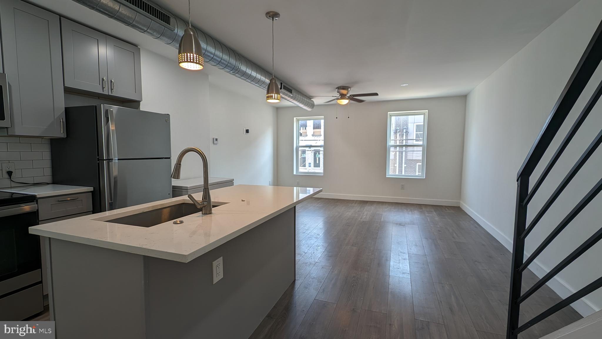 a kitchen with a sink a refrigerator and windows