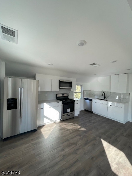 a kitchen with stainless steel appliances kitchen island granite countertop a refrigerator and a stove top oven