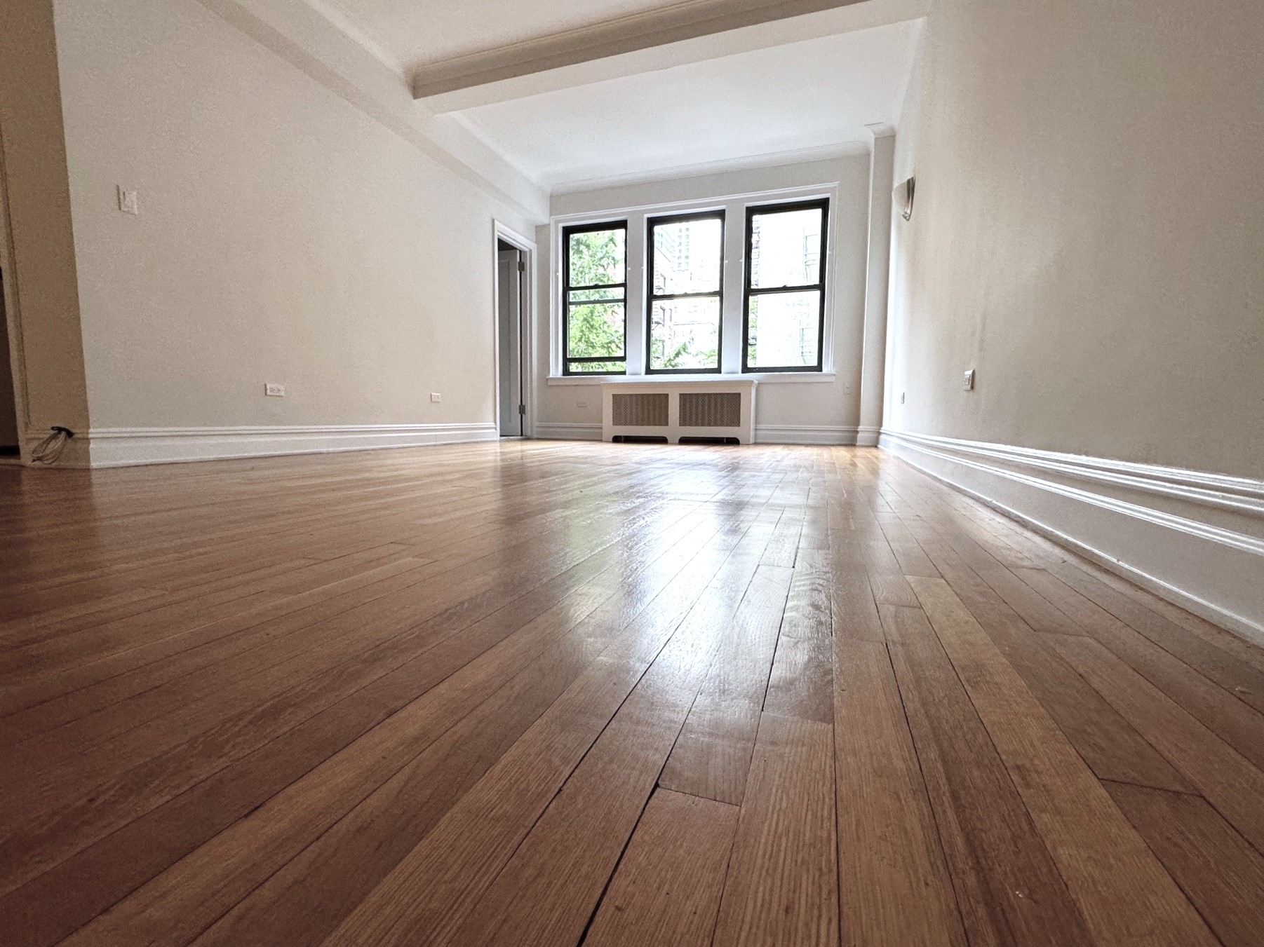 wooden floor in an empty room with a window