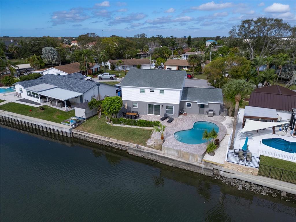 an aerial view of a house with a garden and lake view