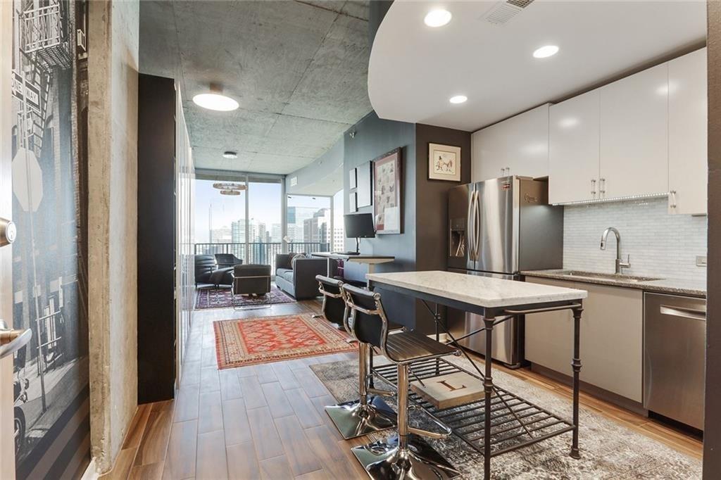 a kitchen with a table chairs refrigerator and wooden floor