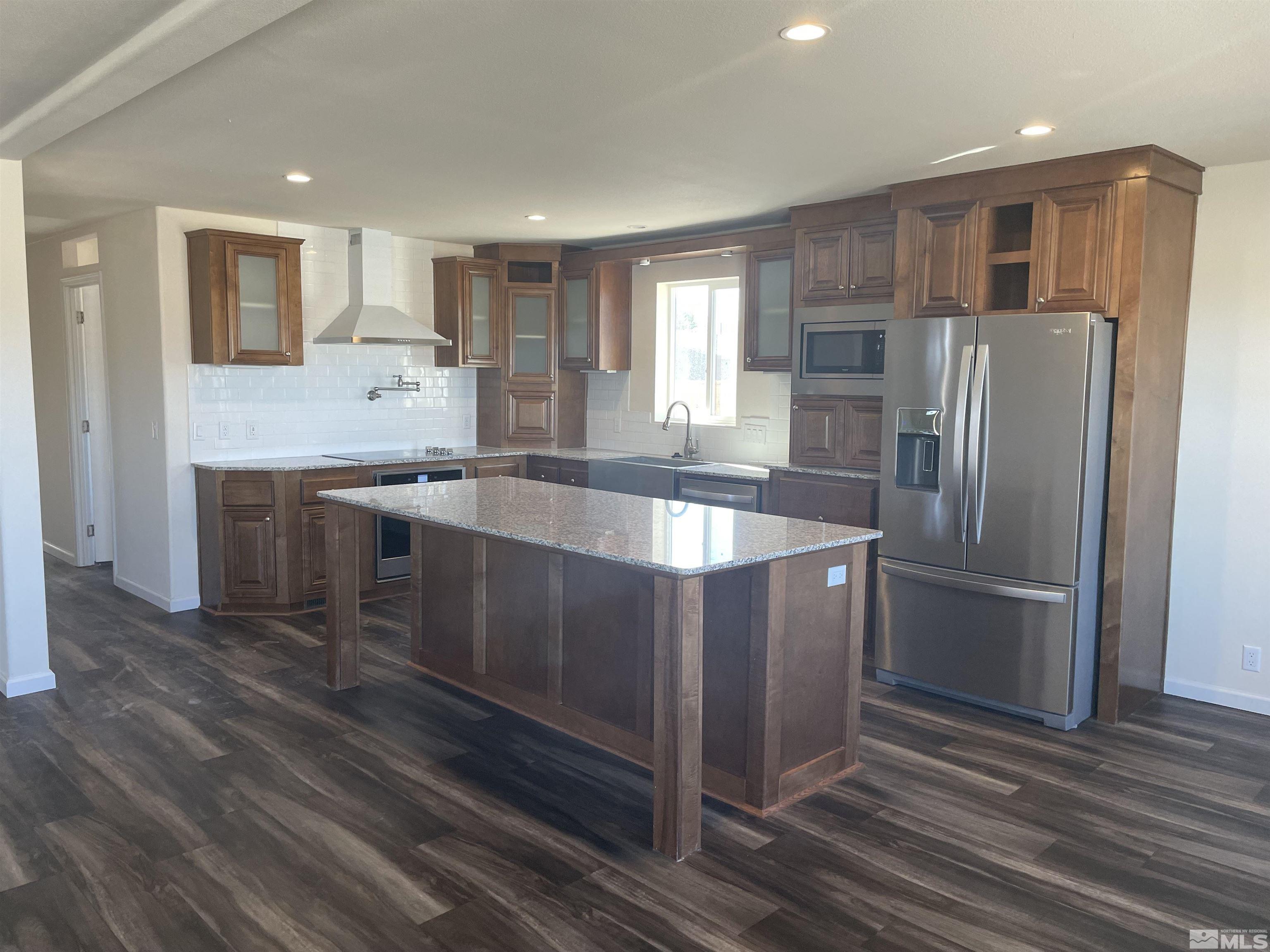 a large kitchen with stainless steel appliances granite countertop a refrigerator and a sink