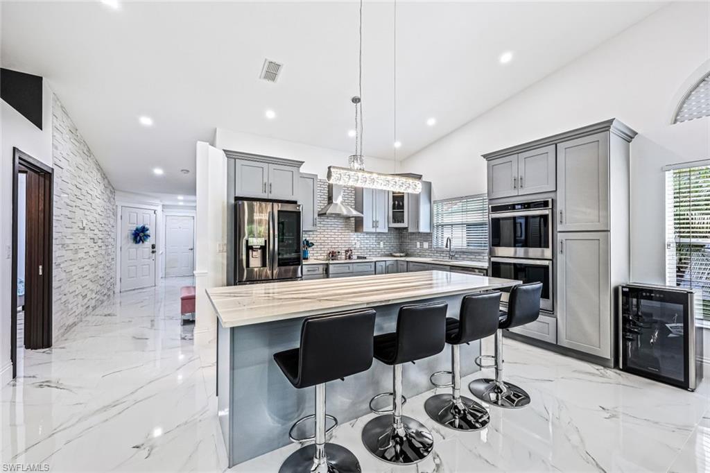 a kitchen with stainless steel appliances kitchen island granite countertop a sink and cabinets