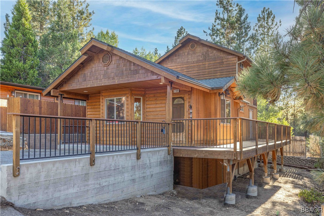 a view of a house with a wooden deck and furniture