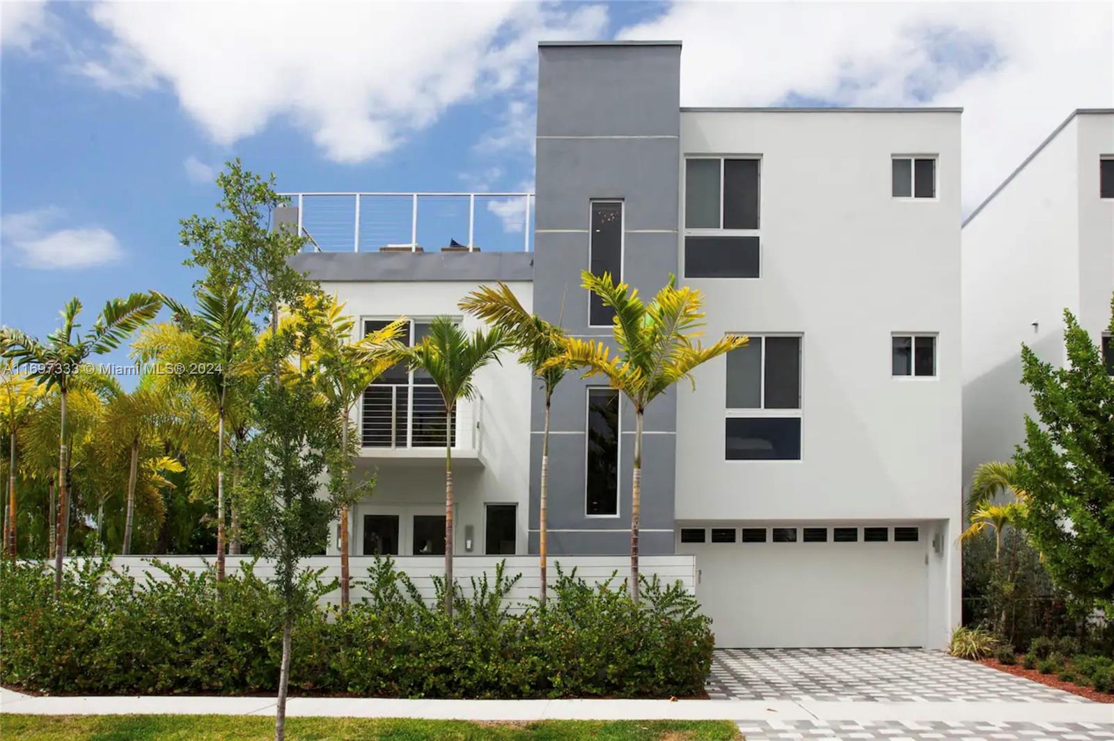 a front view of a house with a garden and trees