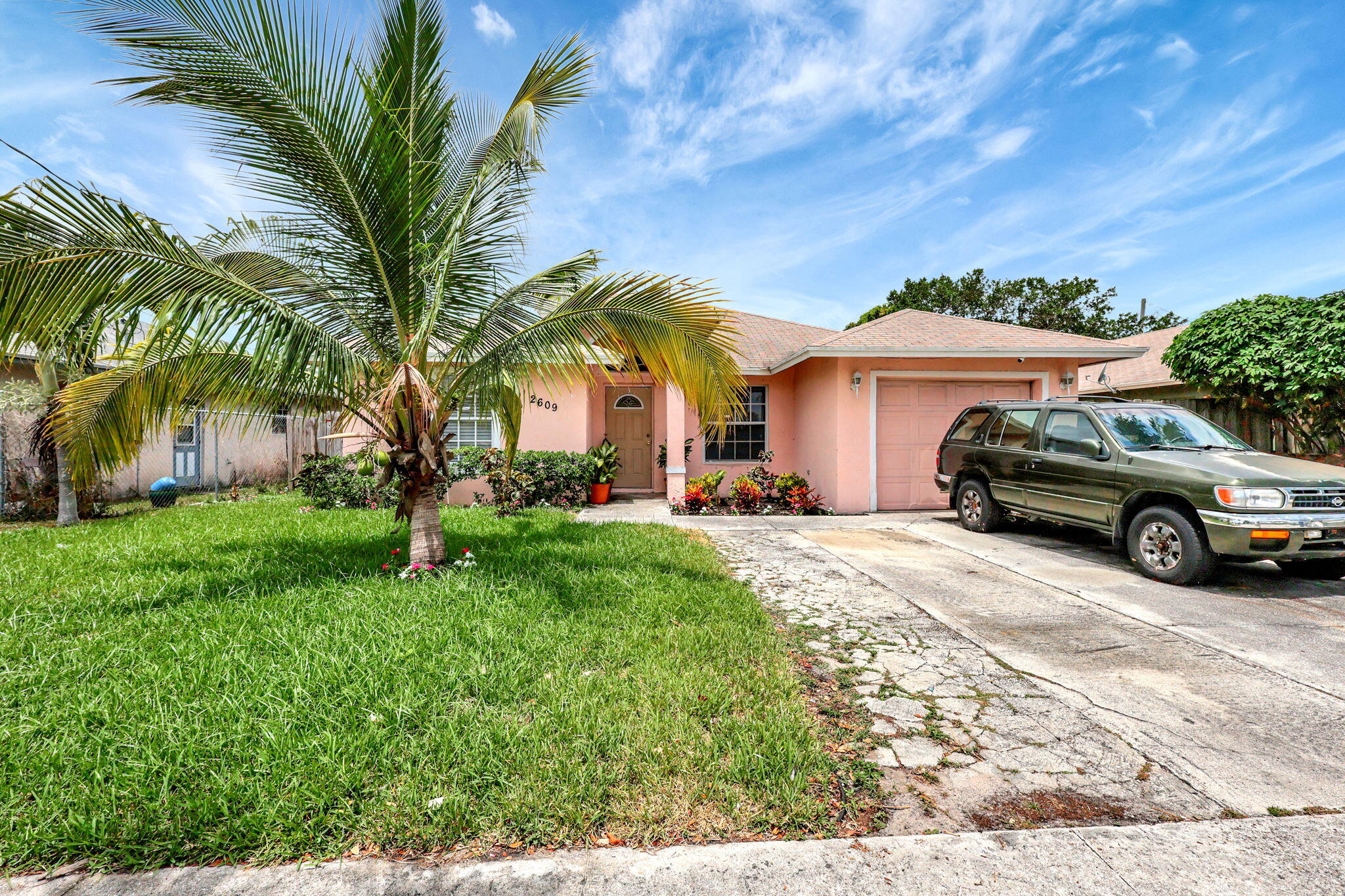 a view of a car parked in front of a house with a big yard